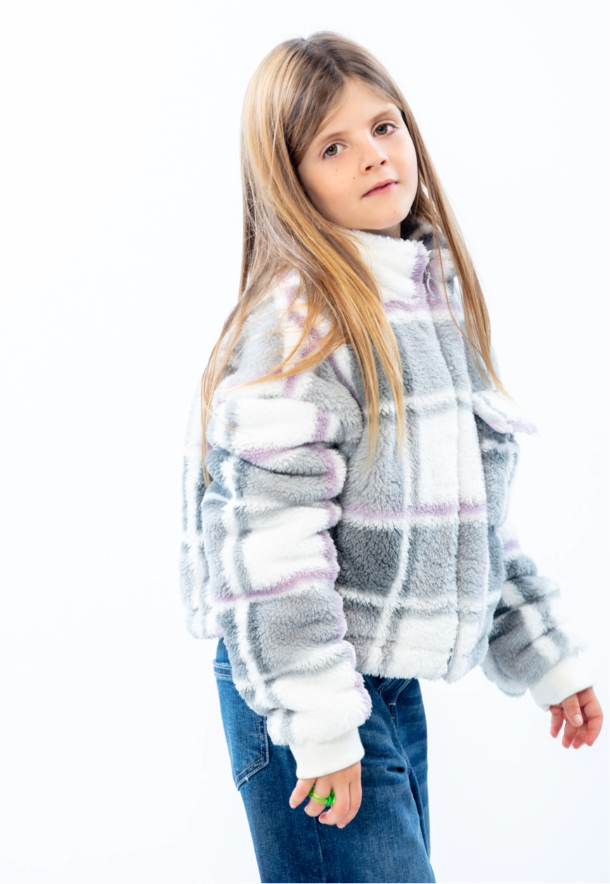 LOSAN- Collection Mountain, side profile of a kid looking at camera, wearing a white and grey plaid jacket