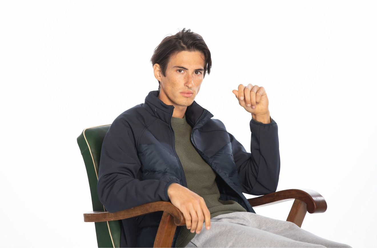 LOSAN - Collection Men Women Daily comfort, uomo seduto su una sedia, con indosso un cappotto blu