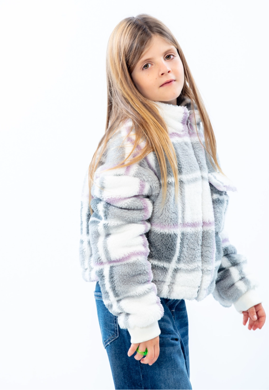 LOSAN- Collection Mountain, profilo laterale di un bambino che guarda la telecamera, con indosso una giacca a quadri bianca e grigia