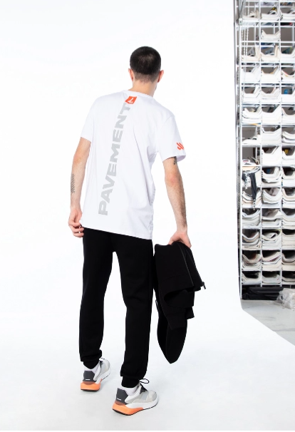 LOSAN - Collection Athleisure - vista posteriore di un uomo in piedi che indossa una camicia bianca e pantaloni neri